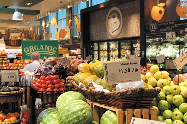 Organic produce aisle at Barons Market with fresh fruit and local signage